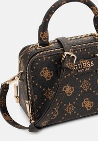 Borsa nera con texture e hardware dorato, caratterizzata da un motivo a logo marrone e doppi manici superiori. Include una tracolla regolabile.