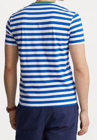 Pruhované tričko v modré a bílé barvě z bavlny, s kulatým výstřihem a zeleným lemem. Krátké rukávy, běžný střih.