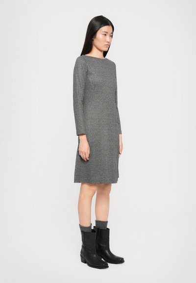 Abito grigio texturizzato con maniche lunghe e scollo a giro, abbinato a stivali neri alla caviglia con accenti in maglia.
