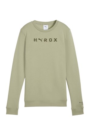 Svijetlo maslinasto zeleni dukserica napravljena od mekanog materijala, ima okrugli izrez, rebraste manžete i riječ "HYROX" otisnutu u tamnozelenoj boji sprijeda.