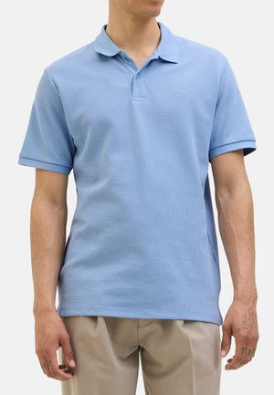 Hellblaues Poloshirt aus strukturiertem Stoff, mit kurzen Ärmeln und Kragen. Mit kleinem Logo auf der linken Brust.