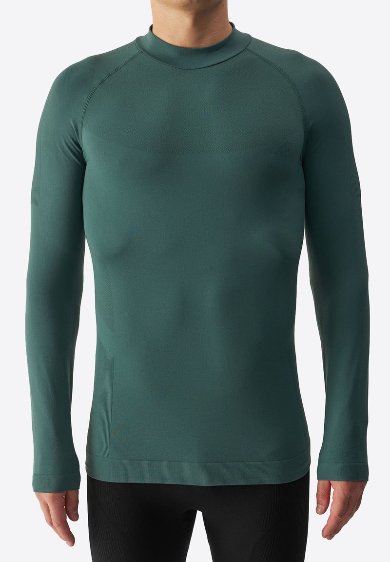 Camisa deportiva de manga larga en azul profundo, hecha de una tela suave y elástica con un diseño ajustado y acentos de canalé en los puños y el escote.