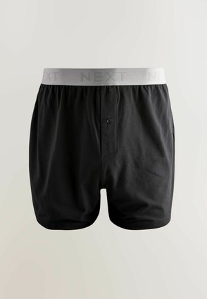 Černé bavlněné boxerky s šedým elastickým pasem, na kterém je decentně vytištěné slovo "NEXT" s texturou. Obsahují detail s předním knoflíkem.