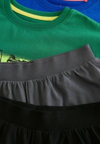 Trzy koszulki w kolorach zielonym, niebieskim i szarym, ułożone na dwóch elastycznych pasach w kolorze czarnym i szarym, z ryflowaną teksturą i różnymi odcieniami.