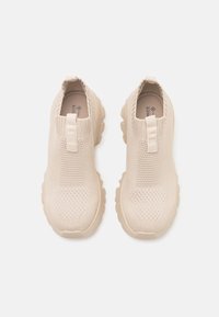 Beige liukastes kaipai su megztu viršumi, tekstūruotu dizainu ir storesniu guminio pado su orui pralaidžia amortizacija. Du traukimo kilpos, kad būtų lengva užsidėti.