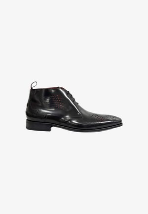 Black leather ankle boot with perforated design, smooth texture, pointed toe, and contrasting red accents. Features a lace-up closure and pull tab.