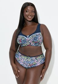 Granatowy kwiatowy komplet bikini z wzorzystym biustonoszem z fiszbinami i szerokimi ramiączkami oraz pasującym, wysokim dołem, oba ozdobione kolorowymi kwiatami.