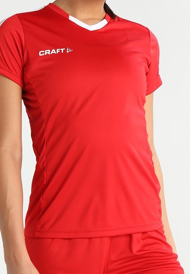 Rød syntetisk sportstrøje med korte ærmer, V-udskæring, hvide detaljer og meshnätter i siden. Har logo på brystet.