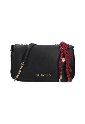Sac à bandoulière en cuir noir avec des accents en chaîne dorée, arborant un pompon logo rouge et une finition lisse et structurée.
