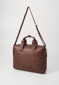 Brown leather briefcase with dual top handles, adjustable shoulder strap, front pocket, and metal hardware accents. Smooth texture.