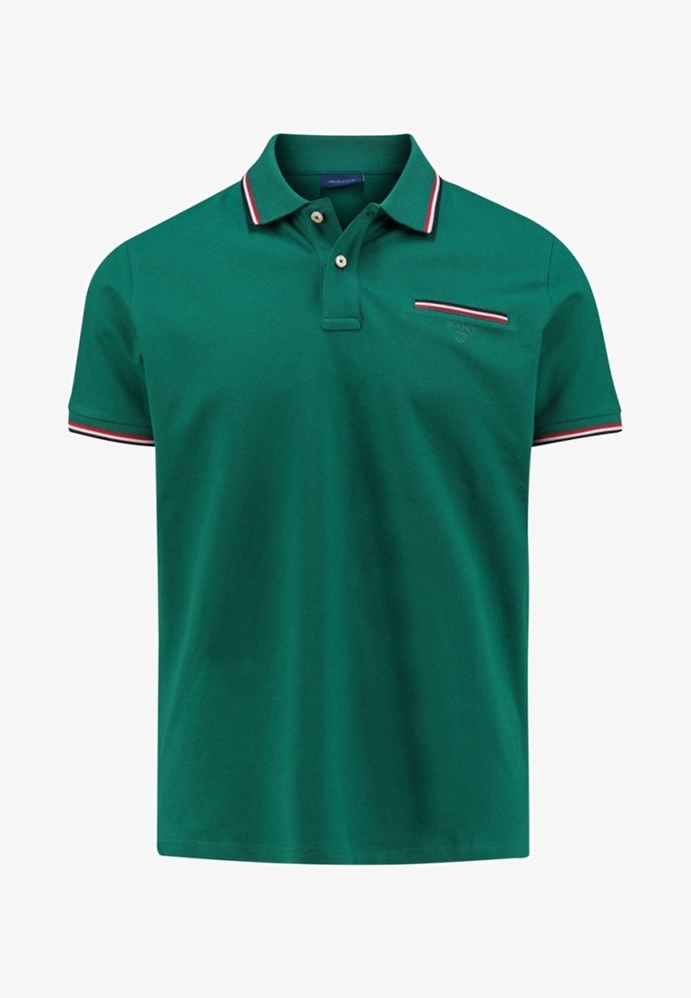 Vihreä poolopaita, joka on valmistettu puuvillasta ja jossa on klassinen malli. Paidan edessä on kaksi nappia, ribatut kaulukset punaisilla ja valkoisilla yksityiskohdilla sekä pieni rintatasku.