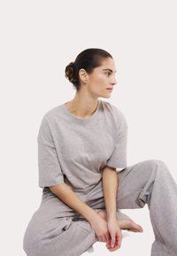 Grijs lounge-set bestaande uit een korte mouw shirt met "SUNDAY" geborduurd en losse broek, gemaakt van zachte, gestructureerde stof.
