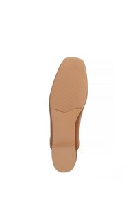Sole di scarpa in pelle beige con una parte superiore liscia e un fondo in gomma testurizzato, con una forma arrotondata e leggermente affusolata.