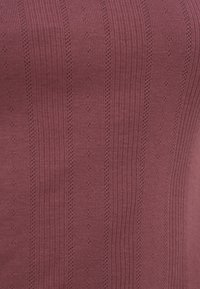 Μωβ πλεκτό ύφασμα με κάθετες ραβδώσεις και μικρά ριγέ μοτίβα με οπές.