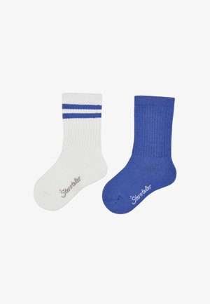 White and blue cotton socks; white sock with blue stripes, blue sock with ribbed texture. Both feature brand logo on the sole.