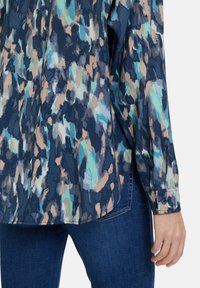 Langarmshirt in een abstract patroon van blauw, groen en perzik, met een knoopmanchet en een licht gebogen zoom. Gemaakt van lichte stof.