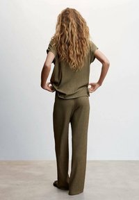 Haut en tricot côtelé vert olive avec un pantalon large, présentant un motif texturé, une coupe ample et des manches courtes. Vue de dos.