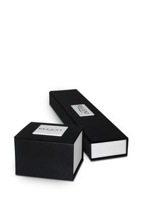 Boîtes en carton noir de deux tailles, avec des surfaces lisses, un intérieur blanc et une étiquette rectangulaire en métal argenté estampillée avec "REGENT."