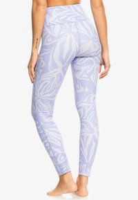 Hög midja leggings i ljus lavendel med ett vitt blomm�önster. Tillverkade av stretchigt tyg, med sömlös design och ankel-längd passform.