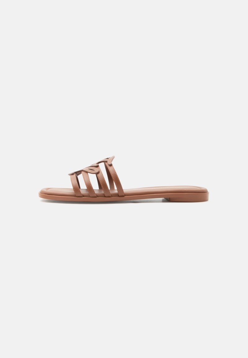 Sandale mule plate marron avec quatre fines lanières, dont une avec un détail décoratif en boucle, présentée de profil sur un fond blanc.
