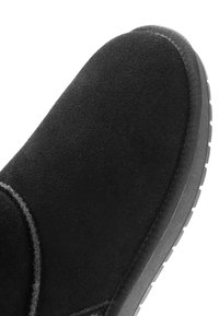 Zwarte schoenen van suede tot de enkel met een ronde neus, voorzien van minimale stiknaden en een gestructureerde rubberen zool. Gladde, zachte oppervlakte.