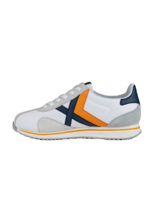 Zapatilla atlética blanca de malla con acentos en gris y azul marino, que presenta una franja naranja y un panel de ante gris texturizado. Diseño con cordones y suela de goma.