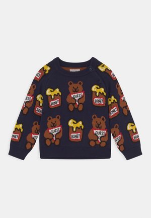 Pull bleu marine avec un motif répétitif d'ours bruns souriants tenant des pancartes "Guess" et des pots de miel étiquetés "Honey" avec du miel qui coule.