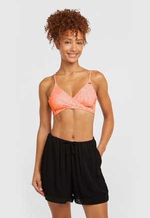 Korallroosa värvi rinnahoidja lillemustriga ja reguleeritavate rihmadega, millele on lisatud mustad, lõdvaltistuvad lühikesed püksid pitsist äärega.