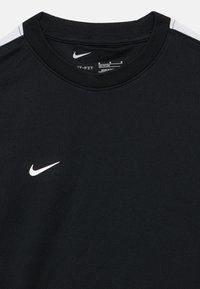 Melnā Nike īsā piedurkņu T-krekls ar apaļu kakla izgriezumu, faktūru audumu un baltu Nike swoosh logotipu uz krūtīm.
