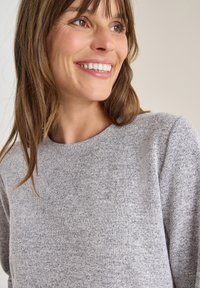 Hellgrauer Pullover mit einem strukturierten Strickmuster, Rundhalsausschnitt und leicht überschnittenen Schultern, der aus weichem, bequemem Stoff besteht.