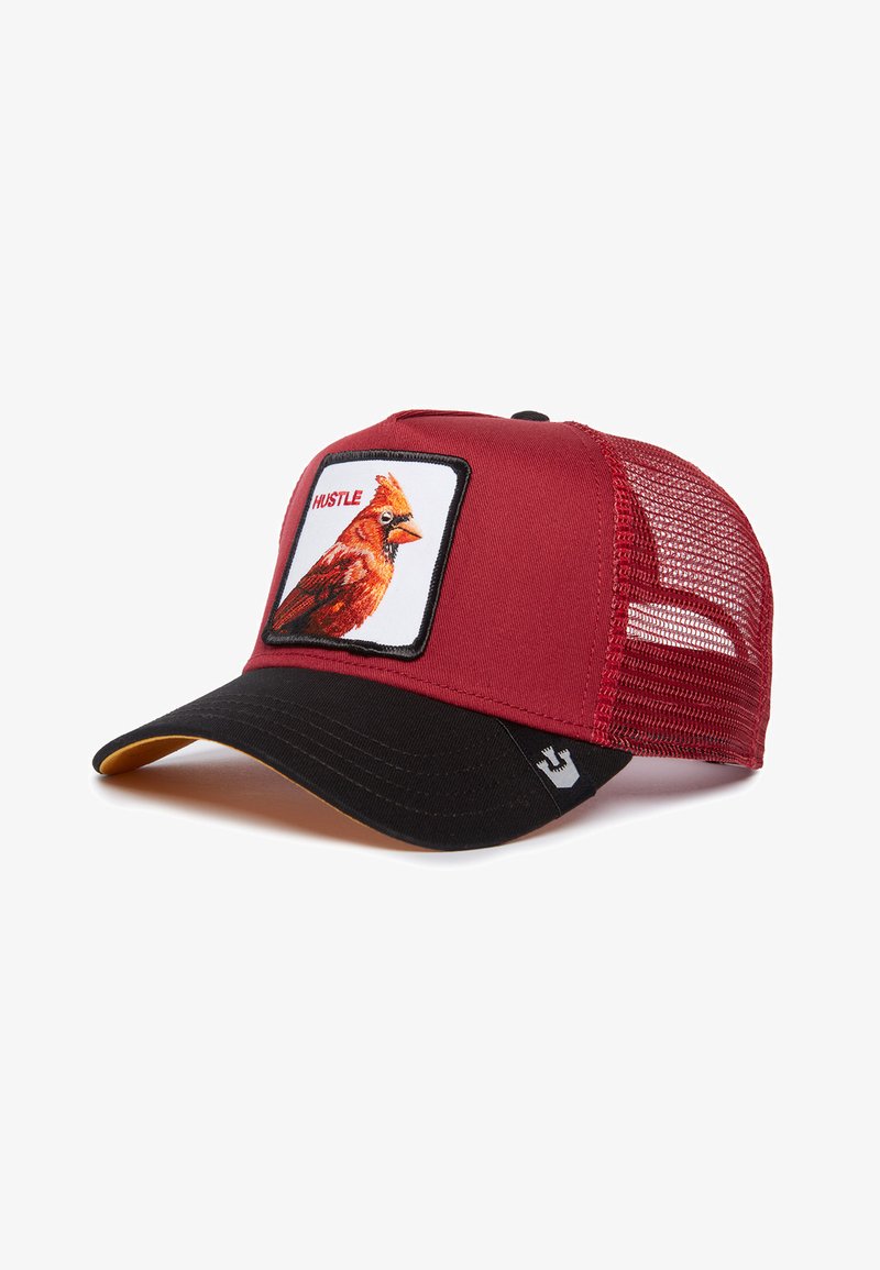 Red mesh-back cap with a black bill, featuring a cardinal graphic and "HUSTLE" text on a white patch. Accents include a yellow underside of the bill.
