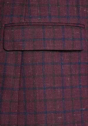 Bordowa tkanina o fakturze z delikatnym wzorem w kratę w kolorze granatowym i ciemnozielonym. Zawiera kieszeń z wypustką z przeszytymi brzegami.