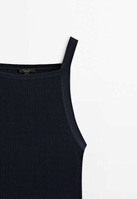 Gros plan d'un haut noir côtelé sans manches avec fines bretelles et encolure carrée sur fond blanc.