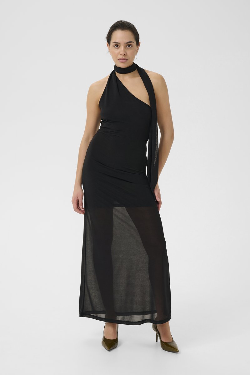 Schwarzes Halter-Maxikleid mit eng anliegendem Oberteil und transparentem Rock. Verfügt über einen Hals-Schal und eine elegante Textur. Getragen mit grünen spitzen Absatzschuhen.