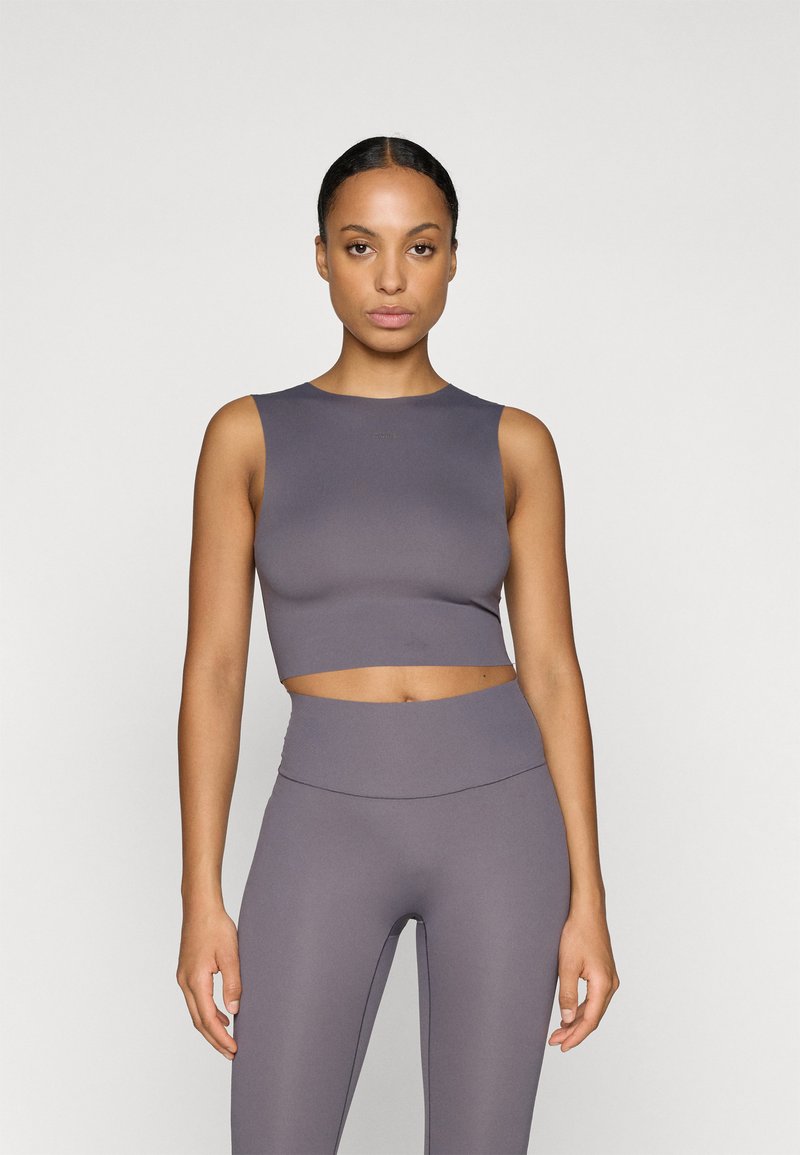 Top corto gris con cuello redondo y diseño sin mangas, combinado con leggings de cintura alta en un tono a juego, que exhiben una textura suave.