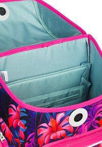 Květinový vzorovaný batoh s živými růžovými akcenty. Interiér obsahuje světle modrou podšívku a několik organizačních kapes různých velikostí.