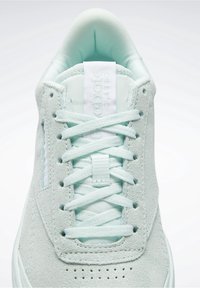 Jasno miętowe sneakersy z zamszowej cholewki, płaskimi sznurowadłami, perforowanym przodem oraz wyściełanym językiem z logo.