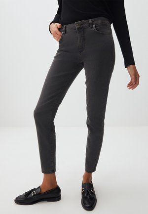 Jeans ajustés gris foncé avec une texture lisse, dotés d'une fermeture à bouton et à zip, de poches latérales et de détails de couture minimalistes.