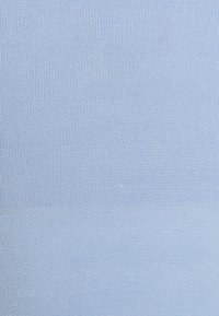 Gros plan sur la texture d'un tissu côtelé bleu clair montrant un motif tricoté vertical.