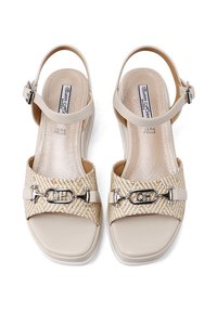 Sandal in pelle beige con una fascetta intrecciata gialla e bianca, dettagli in metallo argentato e cinturino alla caviglia regolabile. Sottopiede liscio e texture.