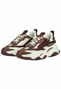 Braun-weiße Mesh- und Ledersneaker mit dicken Sohlen, Schnürdesign, Zugschlaufe und Gummiakzenten auf einer strukturierten Außensohle.