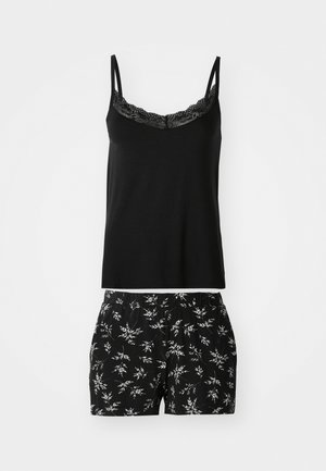 Zwart camisole met kantafwerking, gecombineerd met zwarte shorts met een witte botanische print. Beide gemaakt van zachte, comfortabele stof.