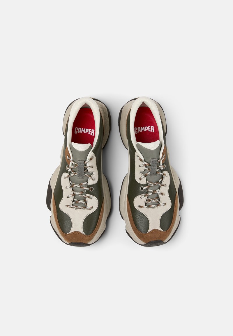 Deux baskets en cuir vert, crème et marron avec une semelle épaisse. Présente des matériaux texturés, des lacets et des semelles intérieures rouges avec le logo "CAMPER".