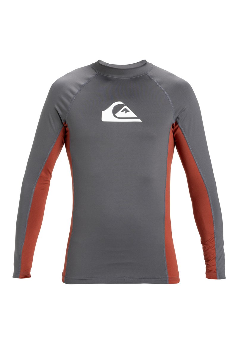 Rash guard u sivoj i smeđe-narančastoj boji, izrađen od rastezljivog materijala. Ima duge rukave, okrugli izrez i bijeli logo na prsima.