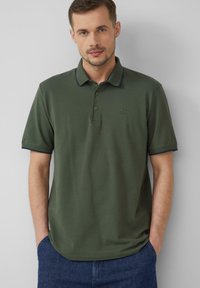 Olijfgroene poloshirt van katoen, met een klassieke kraag, drie knopen en marineblauwe accenten op de kraag en mouwen.
