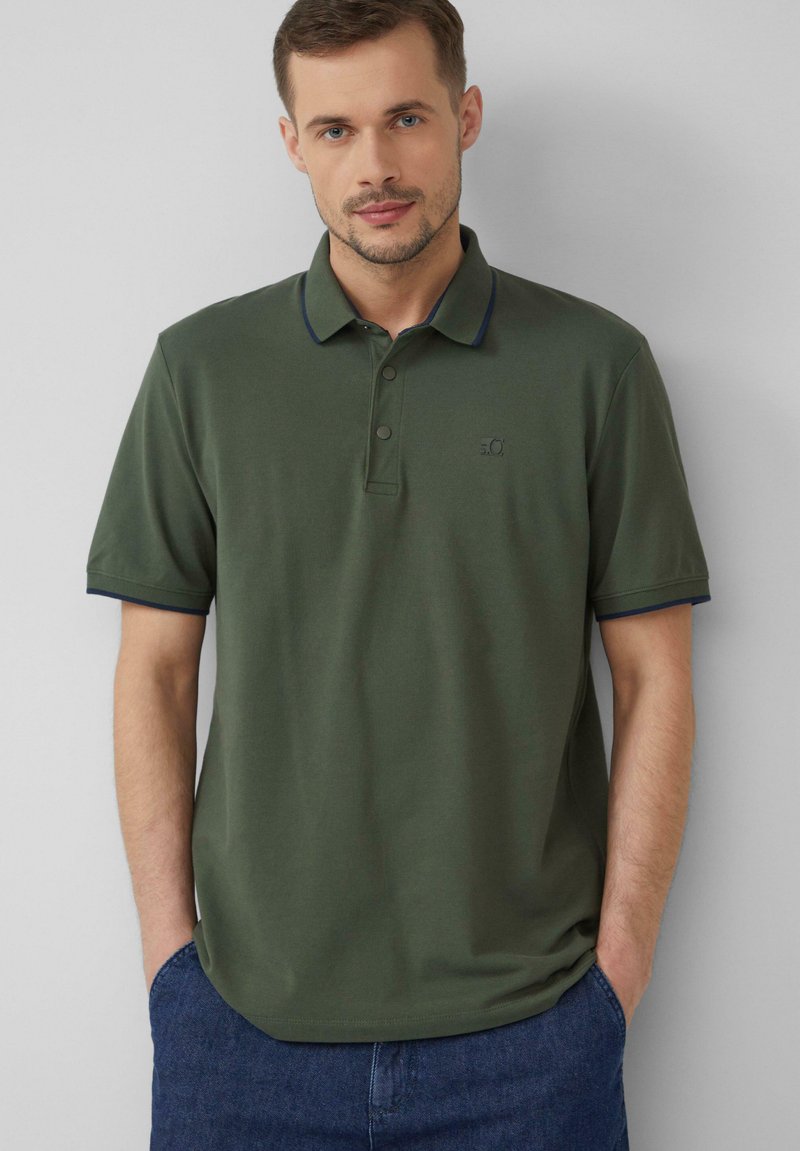 Olijfgroene poloshirt van katoen, met een klassieke kraag, drie knopen en marineblauwe accenten op de kraag en mouwen.