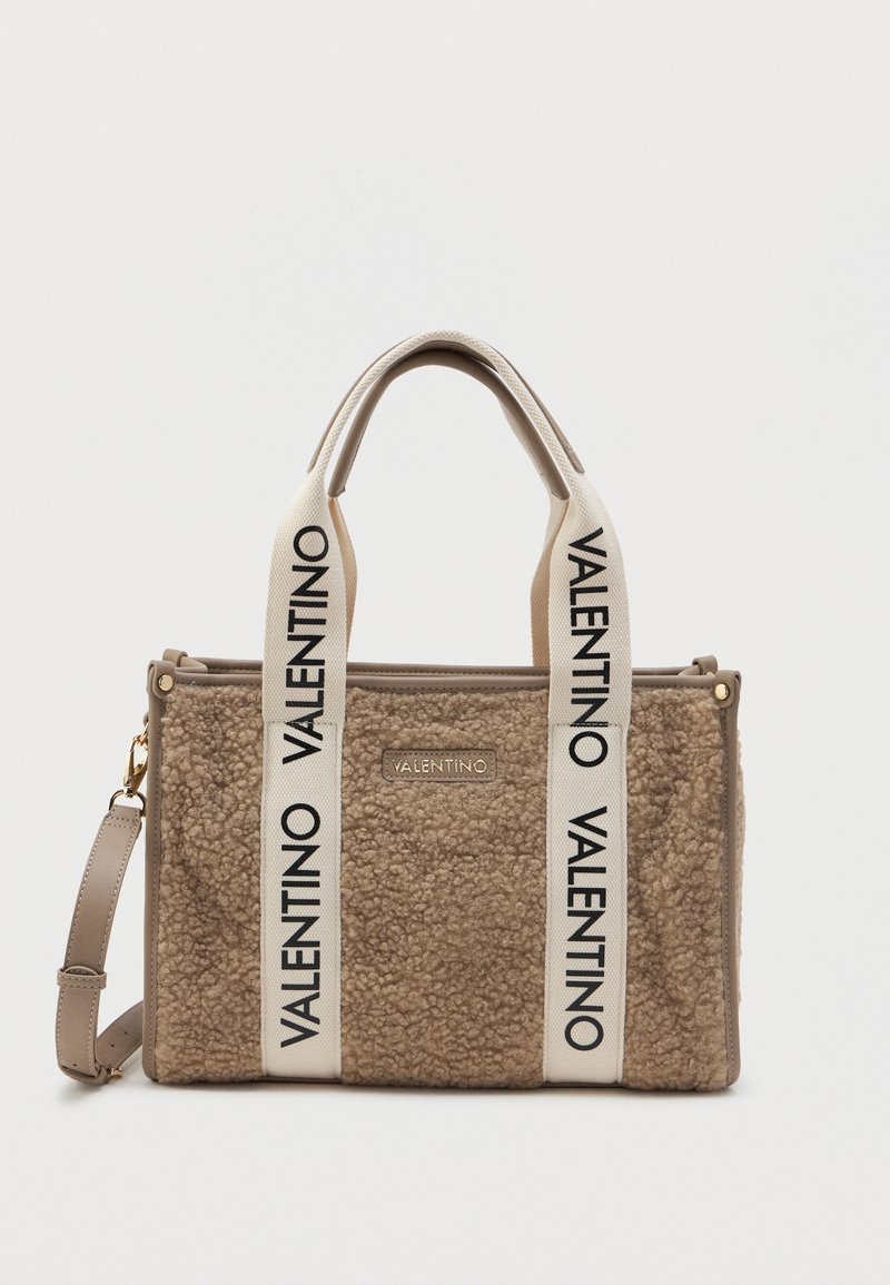 Sac cabas beige texturé Valentino avec larges anses blanches décorées de logos Valentino noirs et une bandoulière détachable.