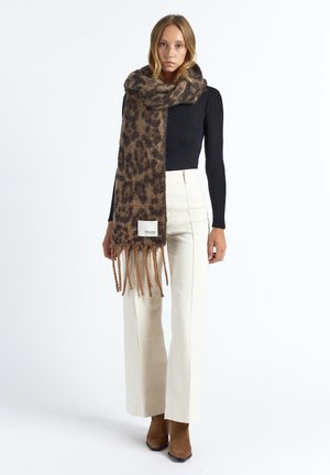 Sjaal met luipaardprint van zacht materiaal, voorzien van franjes aan de randen en een wit label. De warmbruine en beige tinten domineren het ontwerp.