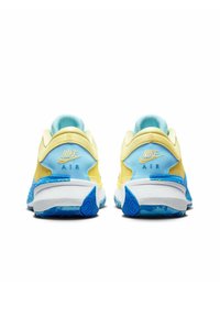 Sneakers Nike Air con una toma gialla, accenti azzurri e una suola blu con un motivo testurizzato. La vista posteriore mostra i dettagli del marchio.