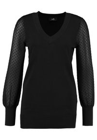 Pull noir avec col en V et corps uni. Manches transparentes texturées avec motif à pois. Poignets et ourlet côtelés. Tissu doux.